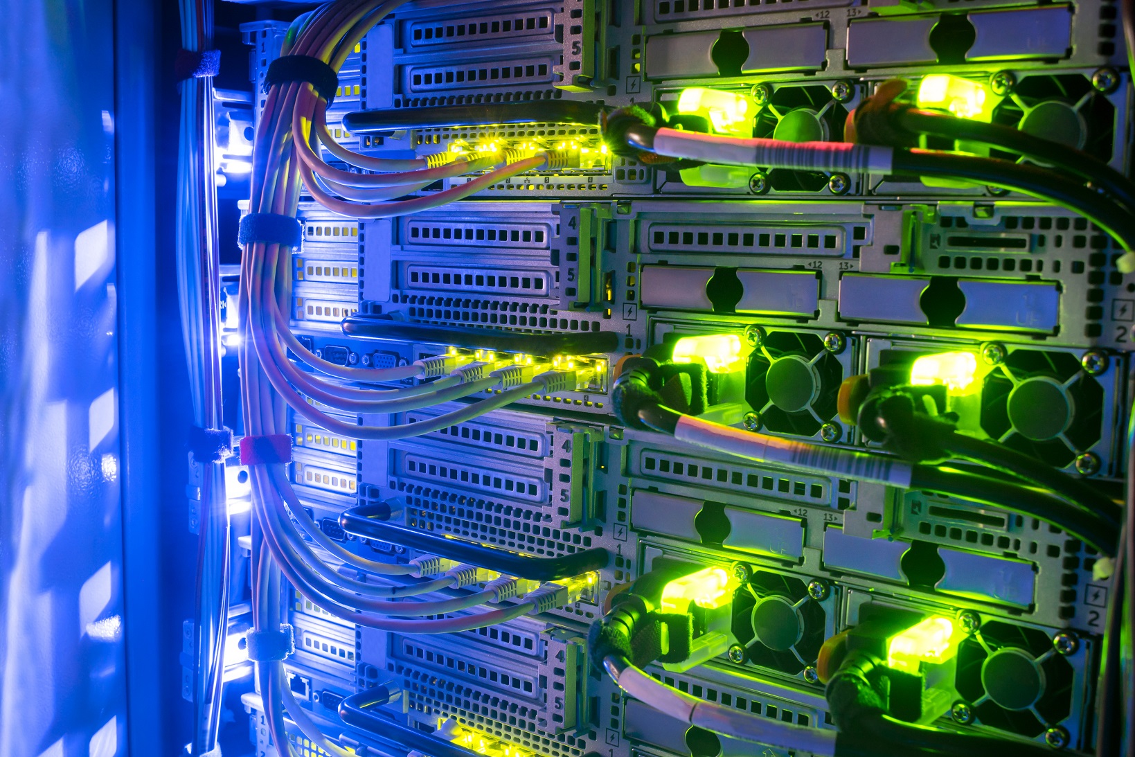 Racks with server equipment are in the dark room of the data center. Colorful indication of the network interests of the Internet router. Information Technology Concept.